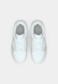 Λευκά και ανοιχτό γκρι αθλητικά παπούτσια με διάτρητα μπροστινά καλύμματα, στρογγυλά κορδόνια, επενδεδυμένους γιακάδες και επενδεδυμένα πέλματα με το λογότυπο. Λείες και υφασμάτινες υφές.