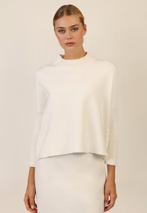 Weißer Strickpullover mit geripptem Kragen und gemusterten Ärmeln. Weicher Stoff, cropped Design, mit geradem Schnitt und lässiger Passform.