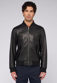 Černá kožená bombera s žebrovanými manžetami a lemem, zapínáním na zip a dvěma bočními kapsami. Hladká textura, klasický design, přiléhavý střih.