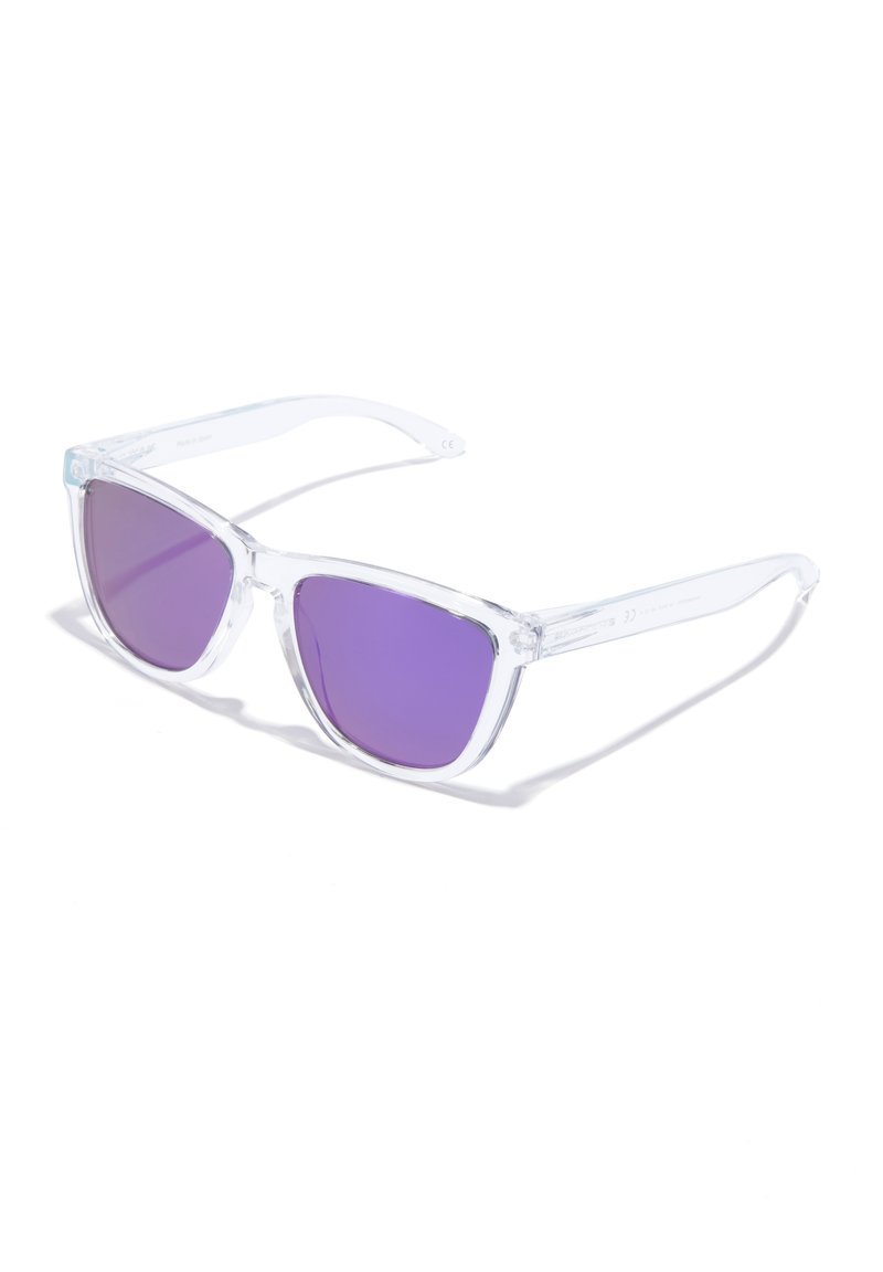 Przezroczyste plastikowe okulary przeciwsłoneczne z kątowymi oprawkami i gradientowymi fioletowymi szkłami. Wyróżniają się przezroczystymi ramionami i minimalistycznymi detalami.