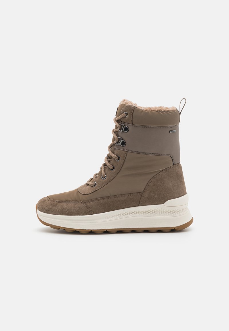 Bottines brunes imperméables présentant une combinaison de textures lisses et en daim, un design à lacets, un col en fausse fourrure et une semelle blanche texturée.