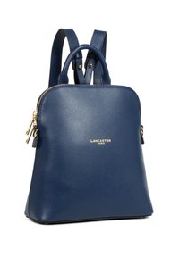 Zaino in pelle blu navy con finitura testurizzata, hardware dorato e maniglia superiore. Dotato di spallacci regolabili e chiusura con zip.