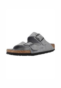 Sandali in suede grigi con cinturino regolabile, sottopiede in sughero e suola in gomma nera. Design aperto con un leggero arco e superficie testurizzata.