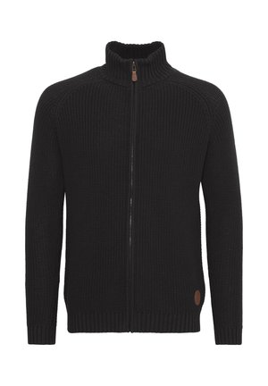 Svart stickad cardigan med hög krage, hel dragkedja, ribbade manschetter och fåll. Har en rund logotypaccent på nedre vänstra sidan.