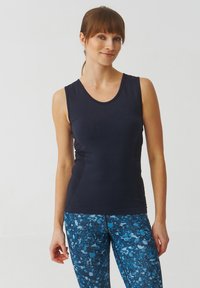 Marineblauw mouwloze sporttop met een ronde halslijn, gemaakt van gladde stof, met een aansluitende pasvorm en subtiele mesh accenten aan de zijkanten.