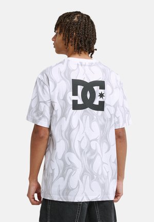 Wit T-shirt met korte mouwen, voorzien van een grijs vlammenpatroon en een groot zwart DC-logo op de achterkant. Gemaakt van zacht materiaal voor comfort.