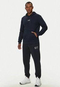 Set di felpa con cappuccio e pantaloni della tuta in navy, realizzato in tessuto morbido, con tasca frontale, cappuccio con cordino e dettagli del logo sul petto e sulla gamba.