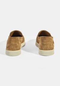 Braune Wildlederschlupfschuhe mit runder Zehenform und beigefarbenem Gummisohle. Sie zeichnen sich durch eine weiche Textur und ein minimalistisches Design ohne sichtbare Verzierungen aus.