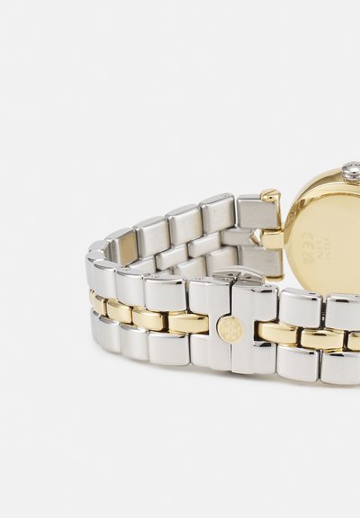 Bracelet de montre en métal bicolore avec des maillons argentés et dorés s'entremêlant, montrant la boucle et le dos d'un boîtier de montre en or.