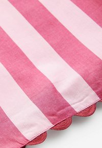 Tissu rayé rose avec des tons alternés de rose clair et foncé. Présente un bord festonné dans une texture rose légèrement plus foncée.