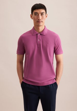 Polo a maniche corte in cotone viola solido, con colletto, pattina con due bottoni e un sottile ricamo sul petto.