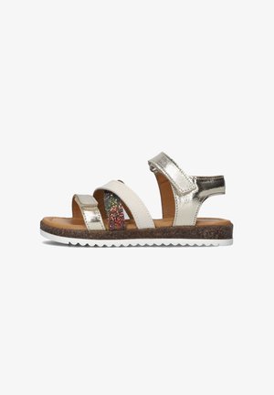 Footwear sandals featuring silver metallic straps, white accents, a glittery band, and a brown textured insole with a white sole.