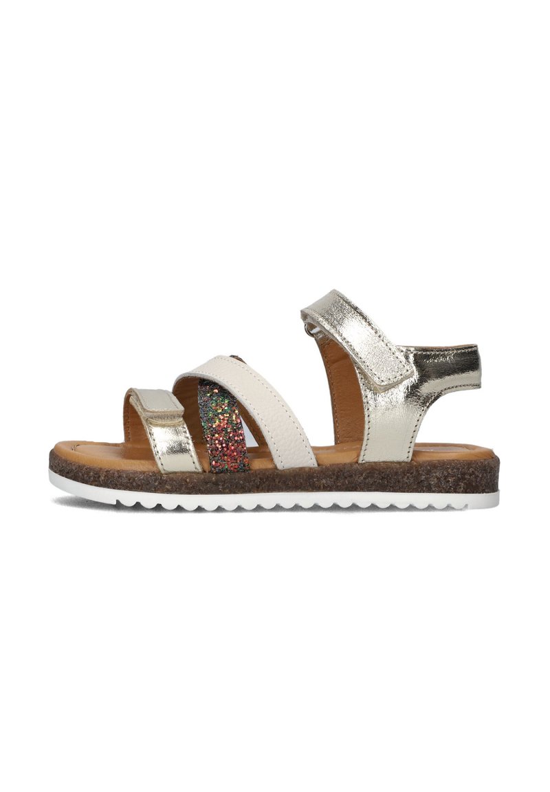 Sandales avec des brides métalliques argentées, des accents blancs, une bande pailletée, et une semelle intérieure texturée marron avec une semelle blanche.