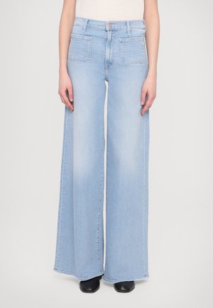 Jean large bleu clair en denim, doté d'une taille haute, d'une fermeture à bouton à l'avant et de deux poches arrière avec une texture décolorée.