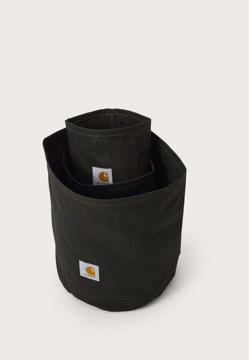Schwarze Stofflagerboxen, eine in der anderen, mit runder Form. Verfügt über ein sichtbares Logo-Patch, robuste Nähte und eine matte Textur.