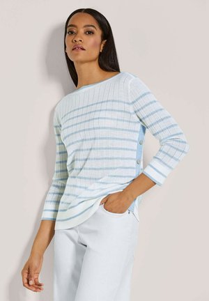 Hellblau-weiß gestreifter Strickpullover mit gerippter Textur, weitem Rundhalsausschnitt und Knopfakzenten an der Seite, kombiniert mit weißen Hosen.