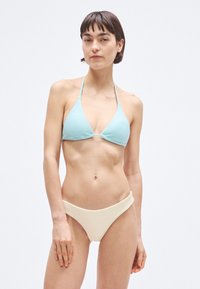 Hele-sinine soonikkoes kolmnurksete tassidega bikiinitopp ja kaelasidemega. Kreemikas soonikkoes bikiinipõhjad laia vöökohaga. Sile tekstuur.