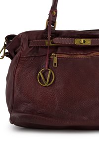 Burgundy leather handbag with a textured finish, gold-tone hardware, a zipper closure, and a decorative logo charm attached to the strap.