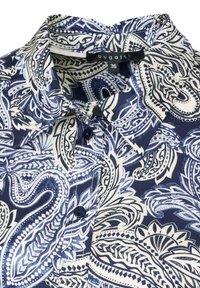Navy blue patterned blouse with a collared neck, featuring intricate white paisley designs, button closure, and soft fabric texture.