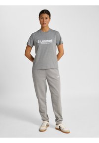 Graues Baumwoll-T-Shirt und passende Sweatpants mit einem weißen "hummel"-Logo, mit kurzen Ärmeln und lockerer Passform. Sneakers mit Streifen.