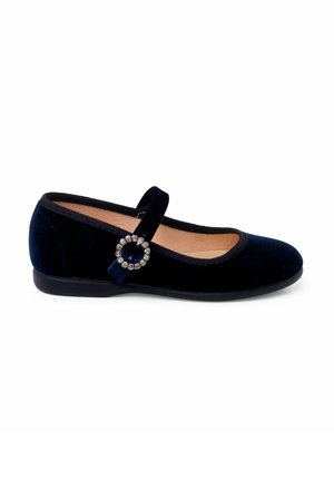 Zapato de ballet de terciopelo azul marino con punta redondeada, tira al tobillo y acento circular de strass. Suela plana y forro interior suave.