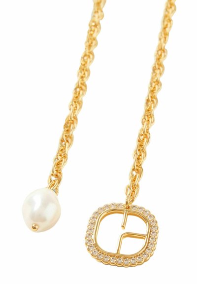 Collier en chaîne dorée mettant en avant une grande perle blanche d'un côté et un pendentif carré bordé de strass transparents.