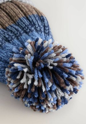 Strickmütze mit einer Farbpalette aus Blau, Braun und Creme, die an der Spitze einen großen, mehrfarbigen Bommel und eine gerippte Textur aufweist.