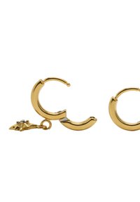 Złote kolczyki koła o zakrzywionym kształcie, ozdobione małym dekoracyjnym zawieszkiem w kształcie gwiazdy z akcentem z przezroczystego kamienia szlachetnego.