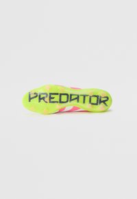 Botín de fútbol con una suela de color amarillo brillante, parte superior en rosa y blanco, con una superficie texturizada y el texto "PREDATOR" destacado.