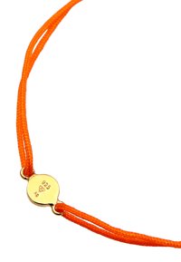 Orange vävd snörearmband med en cirkulär gulddetalj märkt "925" och "A9" med en slät, glänsande yta.