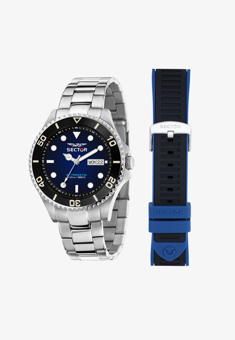 Orologio in acciaio inossidabile argentato con una lunetta rotante nera e quadrante blu. Include un cinturino in gomma blu accanto a un bracciale metallico.