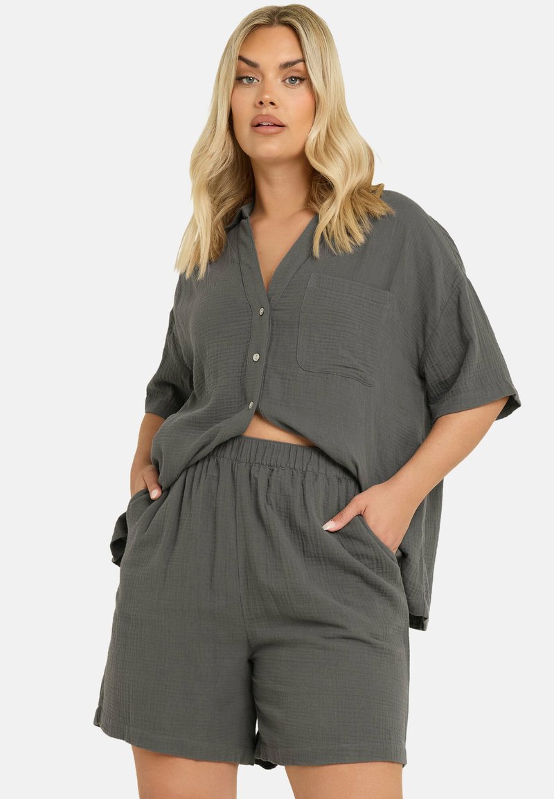 Grå tvådelad outfit bestående av en kortärmad skjorta med knappar och bröstficka samt matchande shorts med elastisk midja. Texturerat tyg.