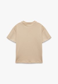 Krótkirt beżowy t-shirt z okrągłym dekoltem i krótkimi rękawami, wykonany z miękkiego materiału, o prostym designie bez wzorów i akcentów.
