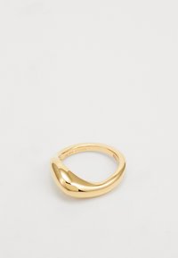 Anillo dorado con un diseño liso y retorcido. Hecho de metal, presenta un acabado pulido y tiene un sutil grabado de marca en su interior.