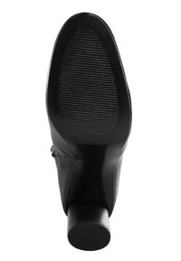 Pohja mustasta nahkakengästä, jossa on pyöristetty kärki, karhennettu kumipohja ja pinottu lohkare korko.