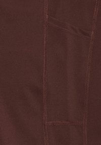 Burgundy tyg med en slät textur, med kontrasterande sömnadsdetaljer och en ficka.