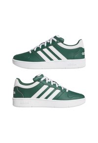 Par de zapatillas Adidas verdes con rayas blancas, cordones y suelas, mostradas desde vistas laterales sobre un fondo blanco.