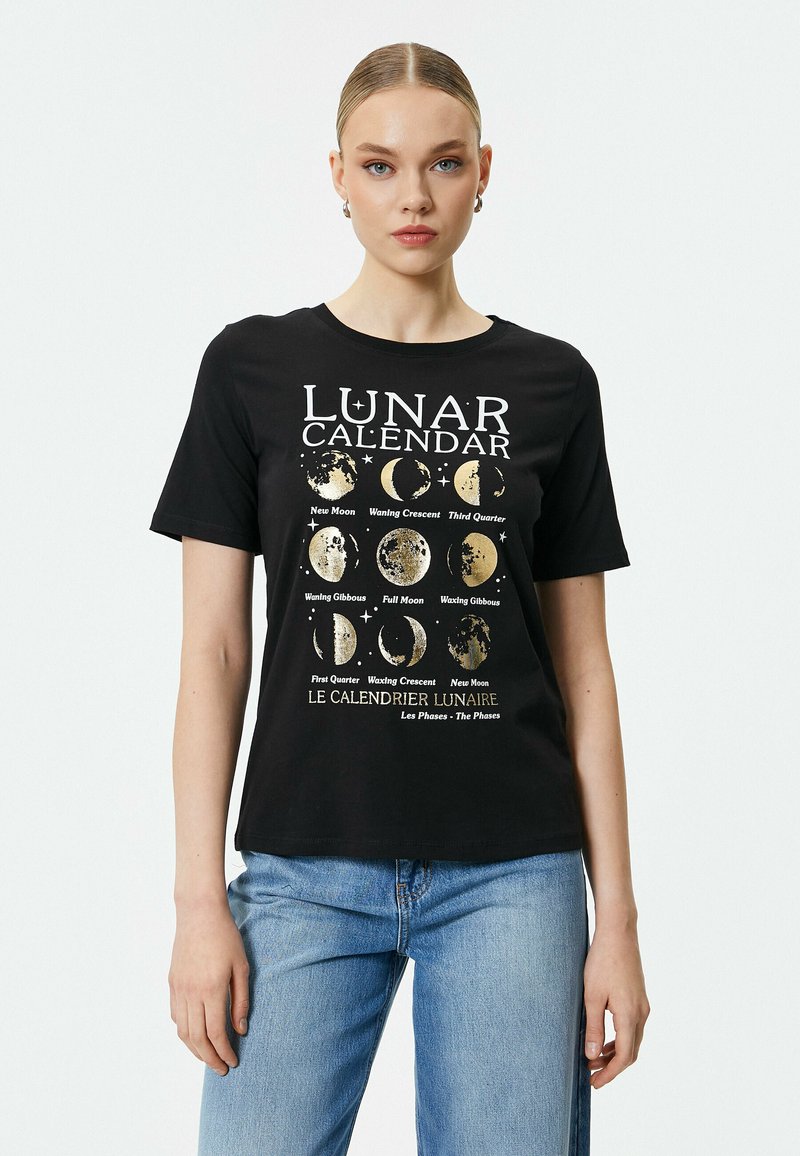 Sort bomulds t-shirt med et lunarkalender grafik i hvid og guld, med månefase illustrationer og tekst på flere sprog.