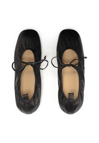 Black leather ballet flats featuring a rounded toe, elasticated edges, and thin bow laces. Soft inner lining and back pull tab detail.