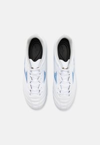 Baskets blanches de sport avec des accents bleus incurvés, tige en cuir texturé, design à lacets et semelles intérieures noires avec un logo.