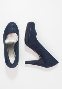 Námořnické modré kožené lodičky na vysokém podpatku z semiše s texturovaným vzorem, tvar mandlového prstu a zúženým stiletto podpatkem. Viditelné stříbrné podšívání.