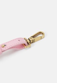 Różowy skórzany pasek z zapięciem w kolorze złotym, z wyraźnymi detalami szwów i małym akcentem w kolorze czarnym.