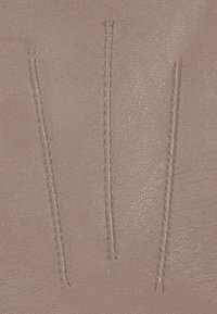 Pink leather material with a textured surface, featuring three parallel decorative stitches aligned vertically.