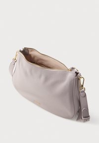 Φωτεινή τσάντα χειρός από δέρμα λεβάντας με υφή πετραδιού, χρυστό φερμουάρ και αποσπώμενο λουρί. Η εσωτερική επένδυση είναι απαλός μπεζ ύφασμα.