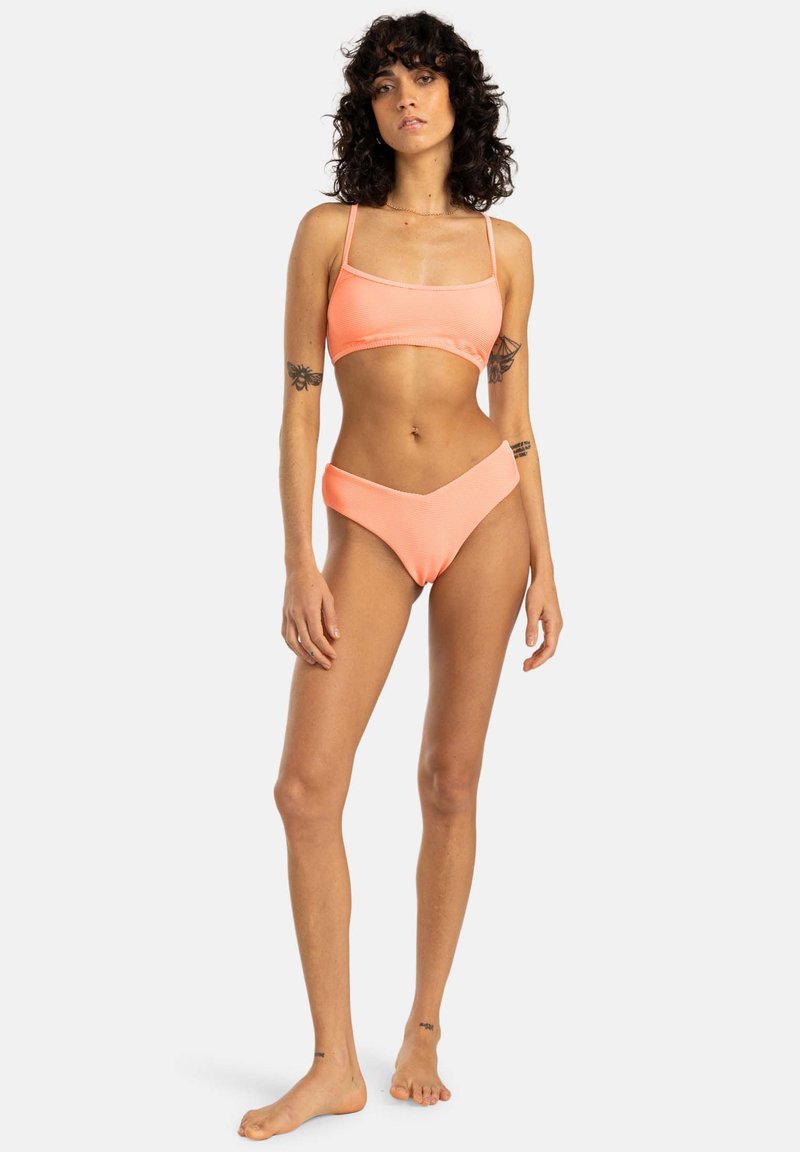 Neon pink bikini with a ribbed texture. Top has thin straps and a square neckline; bottoms feature a low rise and V-shaped front.