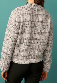 Maglione sconvolto grigio e rosa con un motivo a quadri testurizzato e polsini a costina, caratterizzato da un collo rotondo e un orlo cropped.