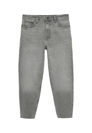 Person iført en sort t-shirt og lysegrå jeans, med hænderne om frontens bæltestropper på jeansene.