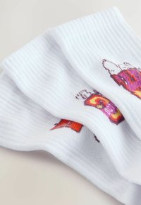 Bijele rebraste čarape s šarenim otiskom šalica, prvenstveno u ružičastoj i narančastoj boji, s mekim tekstilom i vidljivim šavovima.