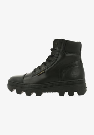 Zwarte hoge boots gemaakt van soepel leer, met een dikke, robuuste zool met opvallende noppen en een G-Star-logo aan de zijkant.