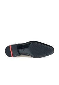 Schwarze Ledersohlen mit strukturierter Gestaltung, rotem Akzent an der Ferse und Nietenverzierung. Glatte Oberfläche mit robustem Grip-Muster.